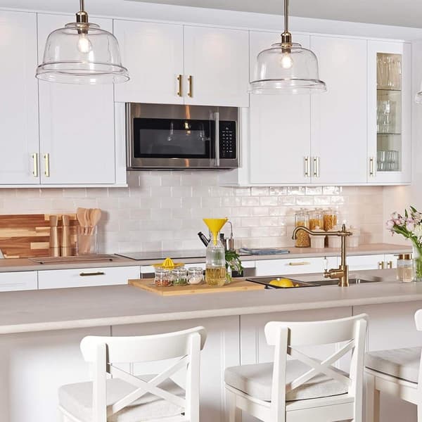 An image of a modern, well-lit kitchen with white cabinets and walls. The kitchen features stainless steel appliances, a light-colored countertop.