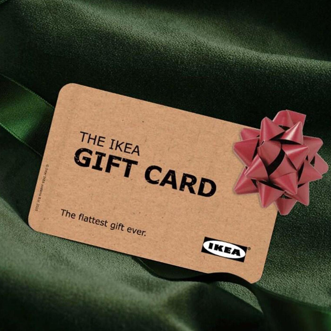 An image of an IKEA Gift card with red ribbon on it on green fabric
