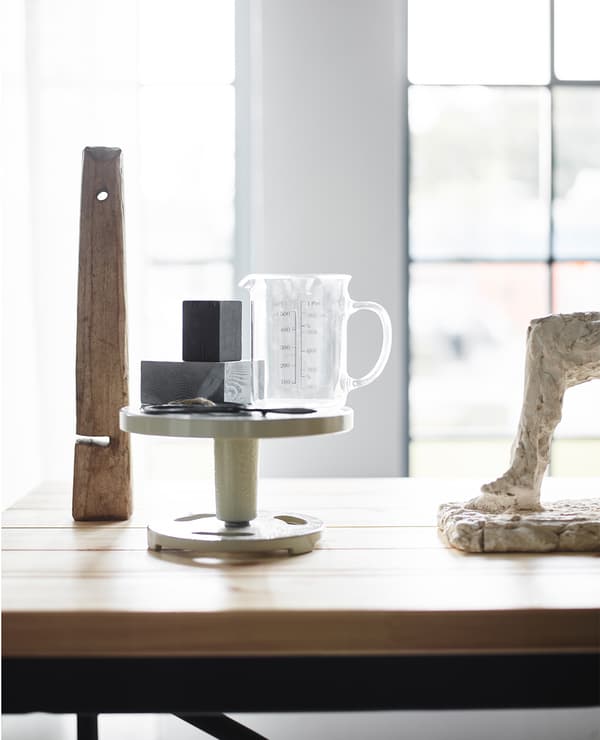 An industrial desk softened by lighter shapes like sculptures and personal objects.