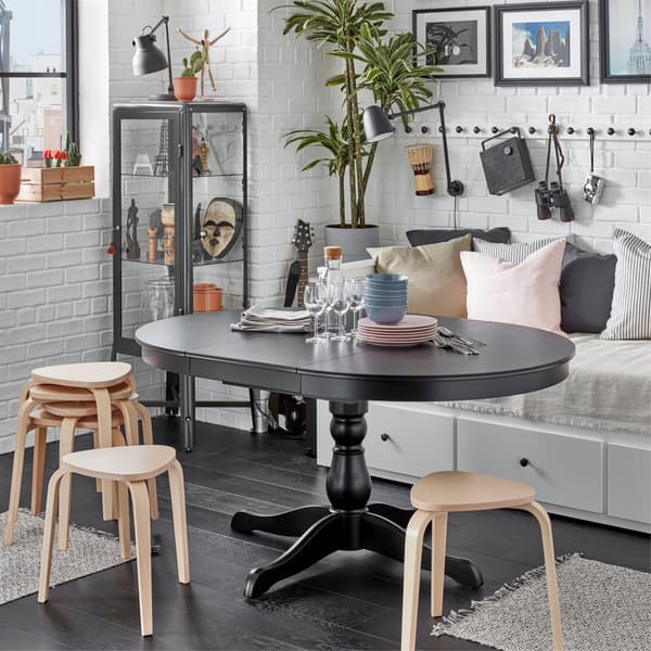 An INGATORP black extendable table is extended and surrounded by KYRRE stools that provide extra seating.