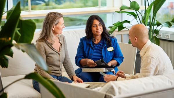 An interior designer meeting with customers on a couch.