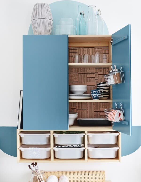An IVAR cabinet painted and turned into a dining cabinet with baskets attached to the doors and wall storage drawers underneath.