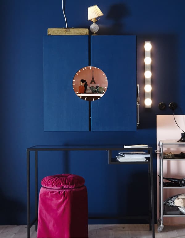 An IVAR cabinet painted pink on the inside and blue on the outside with a circle cut out in the middle to make a vanity.