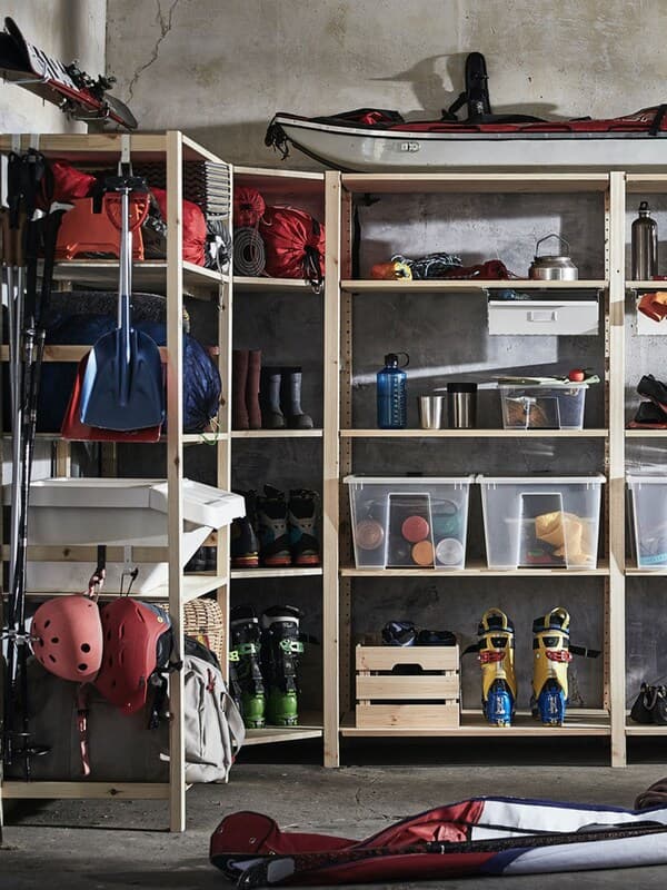 An IVAR shelving unit combination in the garage, holding all sorts of boxes and outdoor sports material.