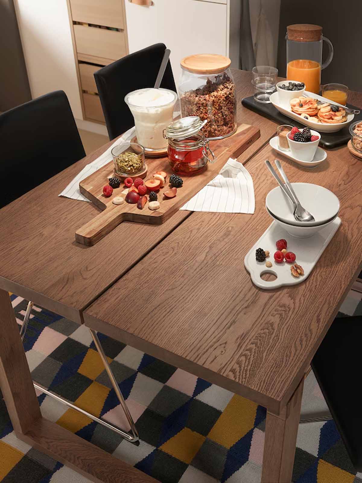 An oak veneer MORBYLANGA table and chairs filled with food in the living room, dining area.