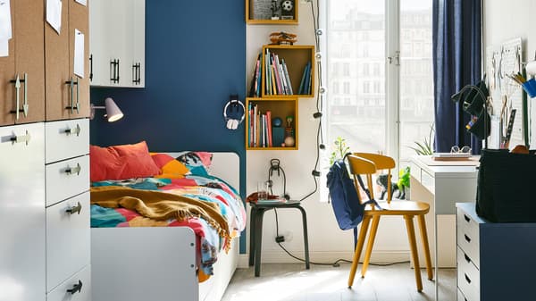 An older child’s bedroom with a SMÅSTAD wardrobe and a SLÄKT bed opposite an OMTÄNKSAM chair and a white MICKE desk.