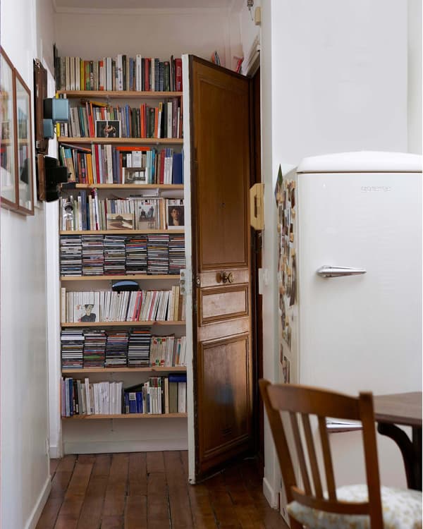 An open bookshelf tucked behind an open door.