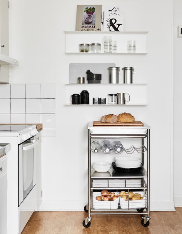 An open cabinet on the kitchen’s side wall is a great space for cookbooks and food containers. A new trolley offers additional flexible counter space.