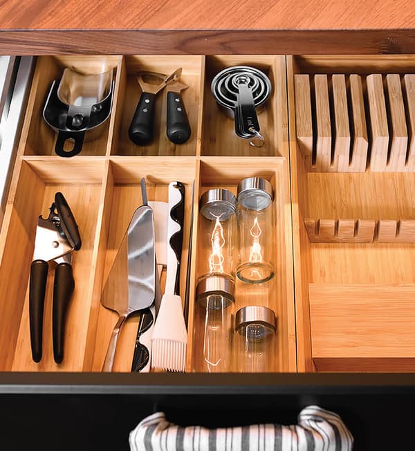 An open drawer featuring kitchen gadget neatly placed in compartments.