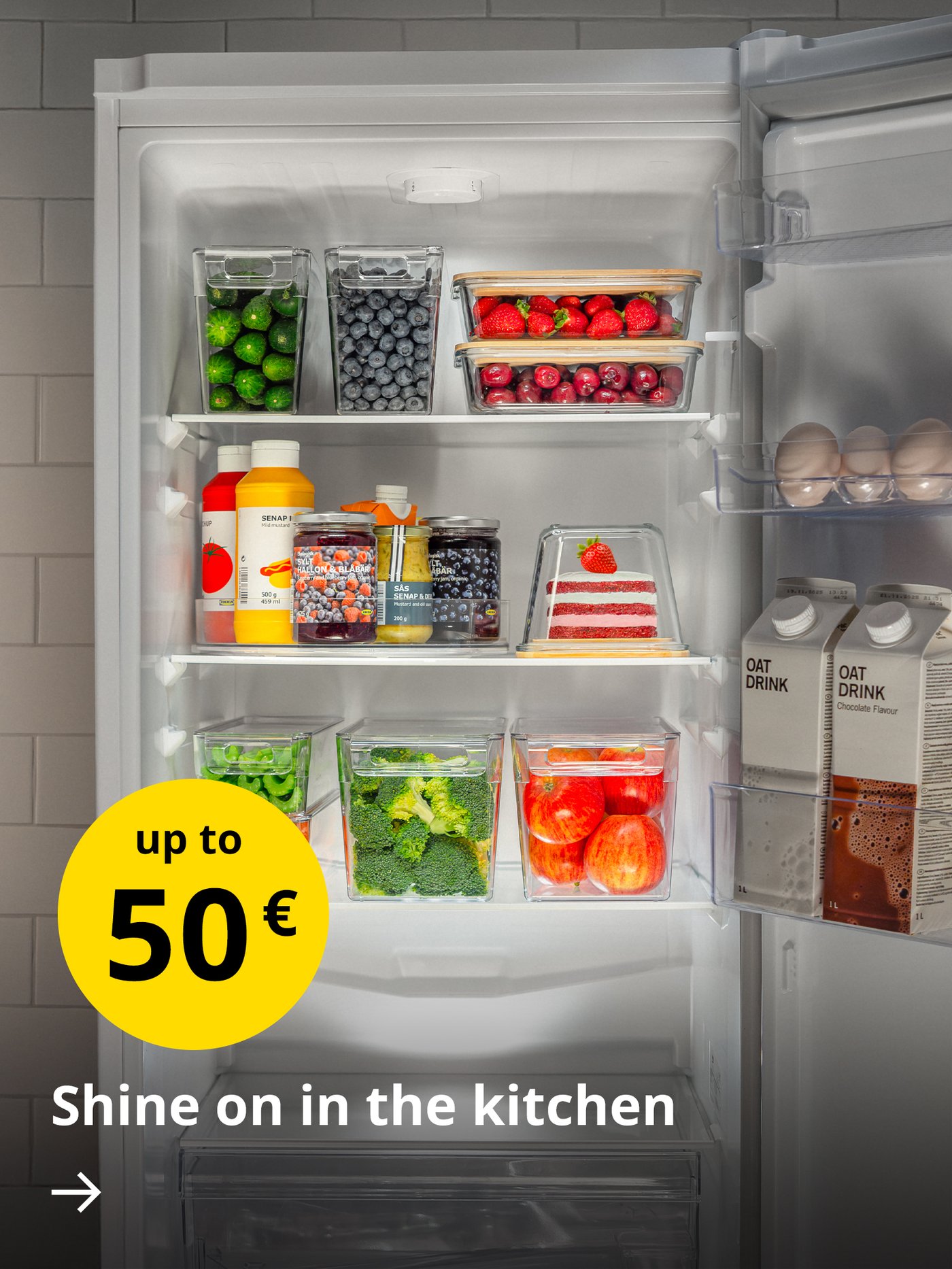 An open fridge with food neatly stored in transparent plastic KLIPPKAKTUS boxes and IKEA 365+ food containers. On the left, the text “Shine on in the kitchen” is visible, along with a yellow circle displaying “up to 50 €”.