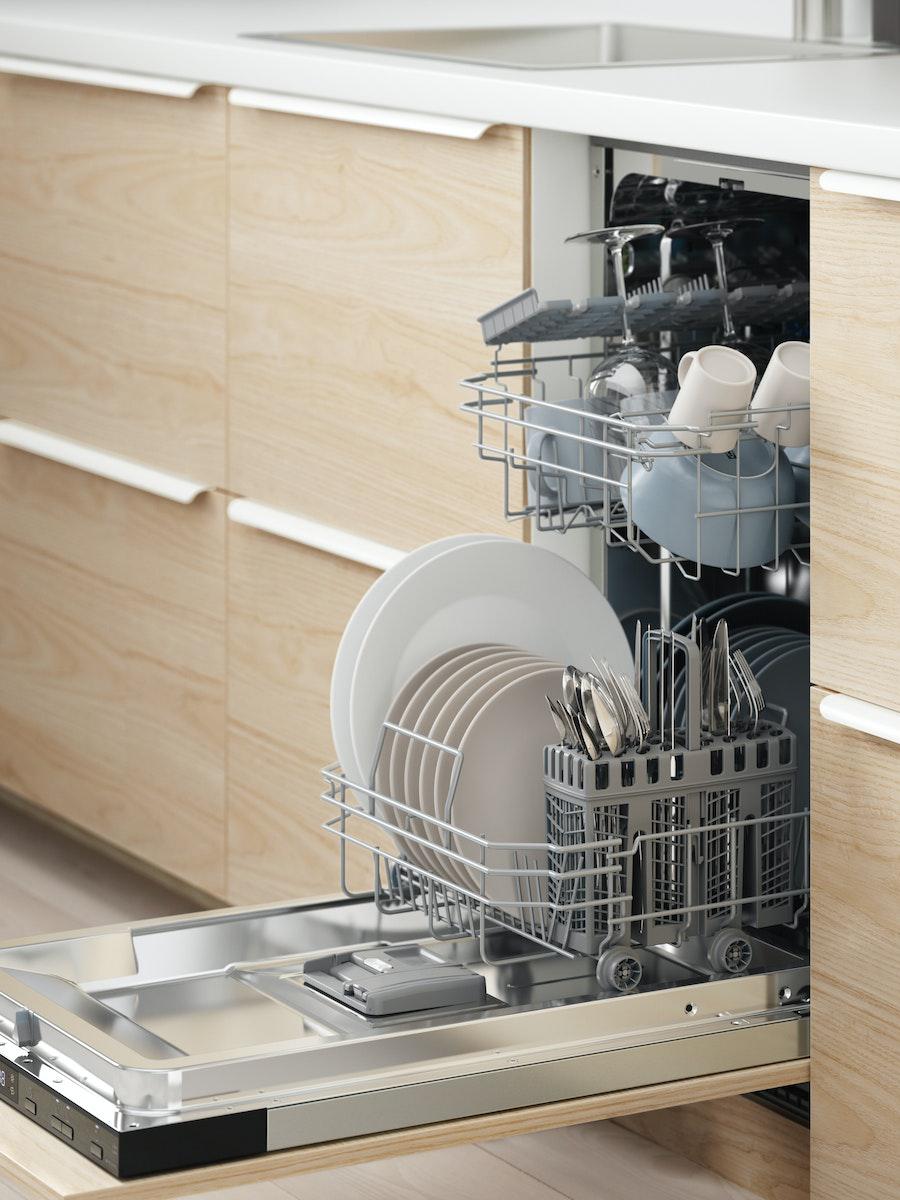 An open integrated dishwasher full of clean plates