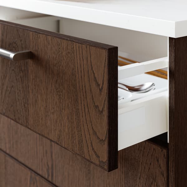 An open MAXIMERA drawer in a METOD kitchen. The drawer is fitted with a dark brown front and stainless steel handle.