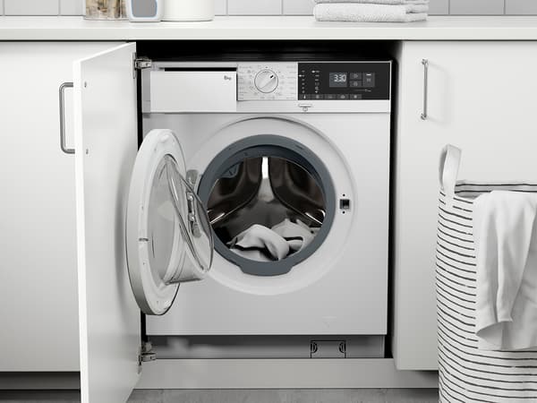 An open washing machine placed under the kitchen counter