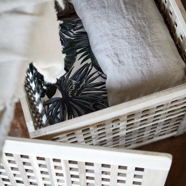 An opened IKEA HOL side table revealing a throw inside.