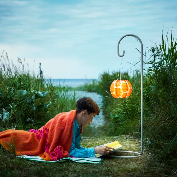 An orange/bright pink KLIPPOXEL throw outside