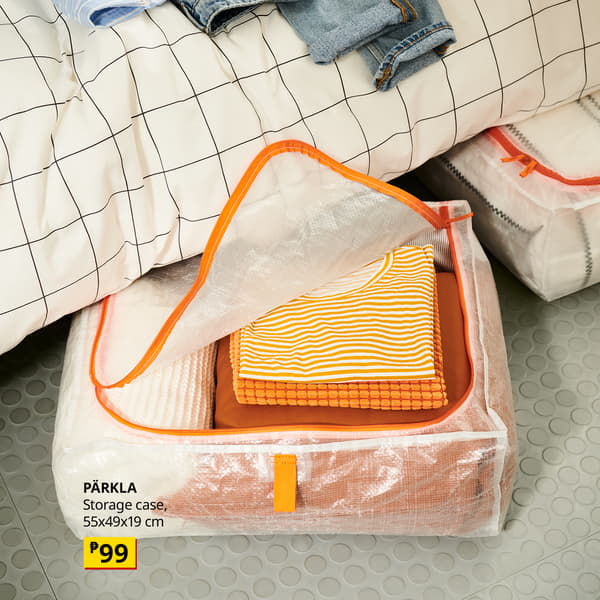 An orange-trimmed transparent PÄRKLA storage case holds folded clothes beneath a bed; a yellow price tag shows ₱99, suggesting tidy, affordable storage.