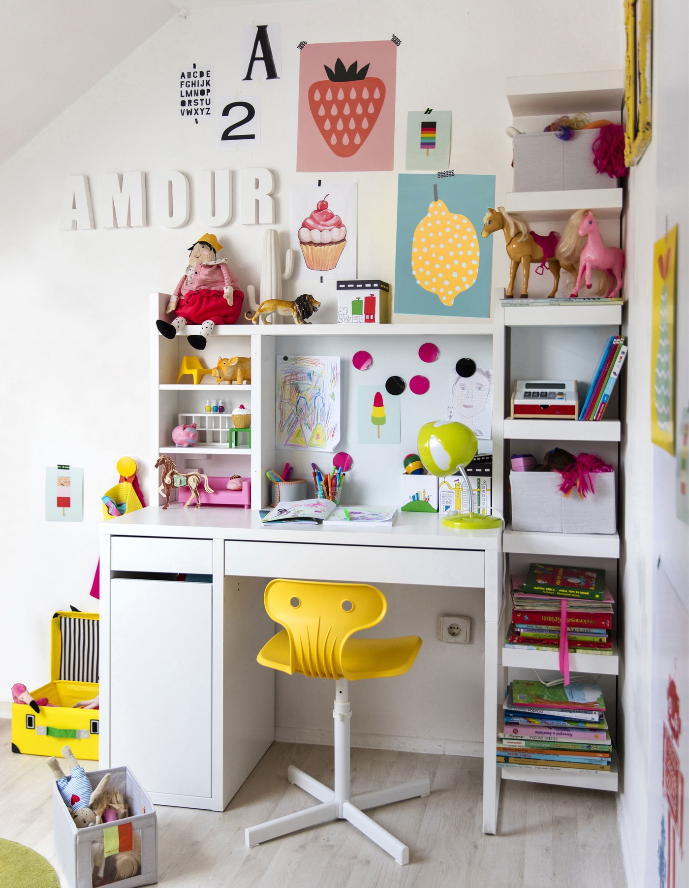 An organised children's work station where the colourful art and toys bring style to the all-white room.