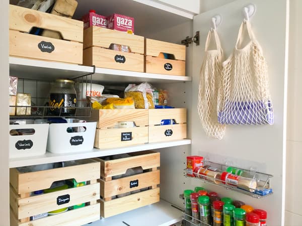 An organised pantry with wooden boxes with labels