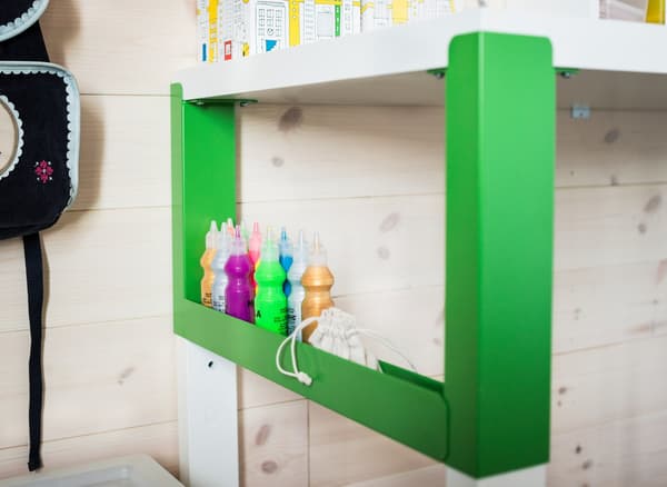 An organised study area for a child that uses a white and green PÅHL desk, a desk shelf unit and see-through boxes with lids.