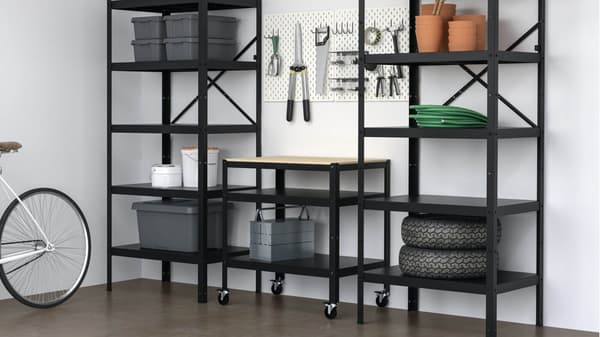 An organized garage is equipped with metal shelves filled with tools and storage bins.