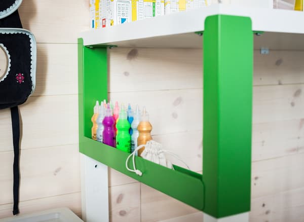 An organized study area for a child that uses a white and green PÅHL desk, a desk shelf unit and see-through boxes with lids to easily store small stuff.