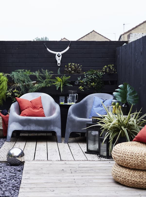 An outdoor terrace with grey chairs and plants.