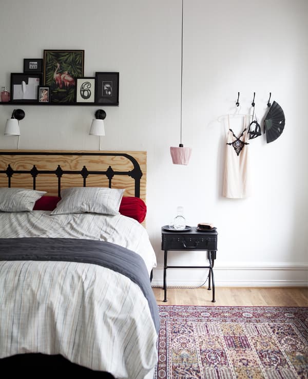 An upside-down lampshade hangs over a bedside table.