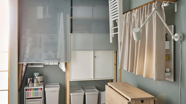 Angolo di una stanza con materiali per hobby organizzati in contenitori.