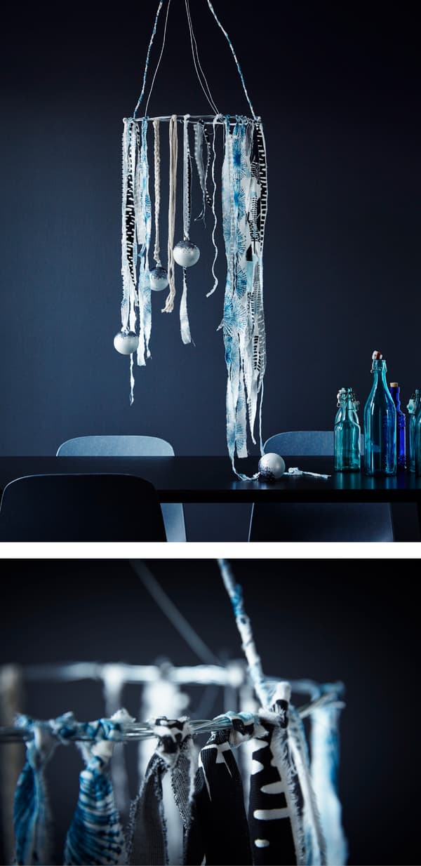 Anneau suspendu au-dessus de la table et garni de bandes de tissu multicolore et de décorations de Noël dans les tons de bleu