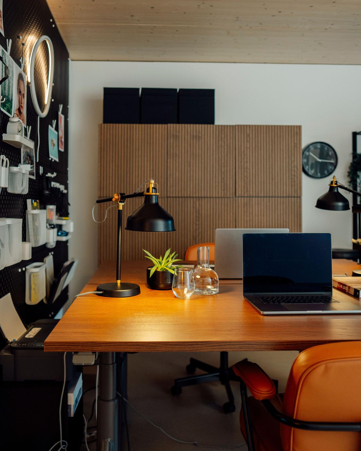 Ansicht eines Doppel-Arbeitsplatzes mit zwei an den Längsseiten zusammengestellten Schreibtischen und einem grossen Büroschrank dahinter. 