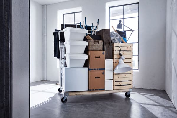 Appartement emballé et déplacé dans des boîtes, sur un chariot.