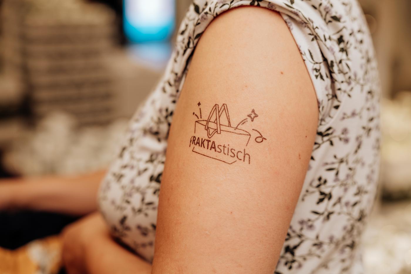 Arm einer Person mit temporärem IKEA Tattoo „NATURTISCH“ beim IKEA Festival.