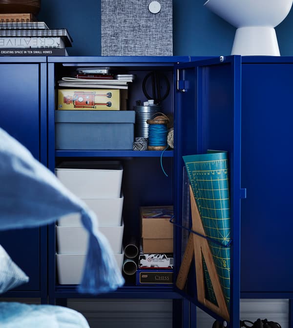 Armario de metal LIXHULT azul oscuro con varios artículos organizativos, cajas de almacenaje y recipientes.