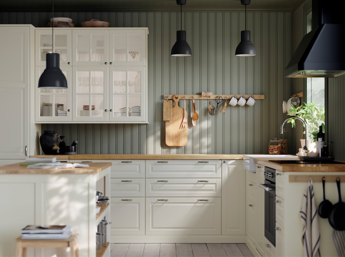 Armarios con portas de vidro BODBYN en cor óso, almacenaxe con portas BODBYN en cor óso e artigos de cociña pendurados de ganchos.