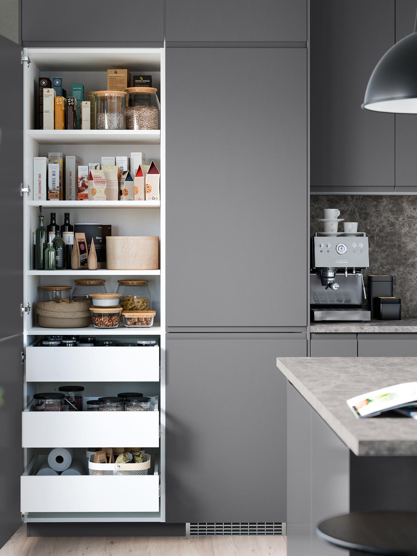 Armarios de cocina de color gris oscuro. Dos de los armarios tienen puertas abiertas que muestran cajones y estantes donde se almacenan alimentos secos en el interior.