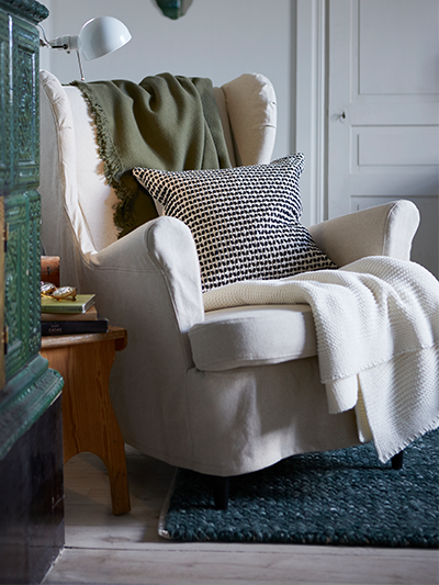Armchair with throw pillow and blanket on it