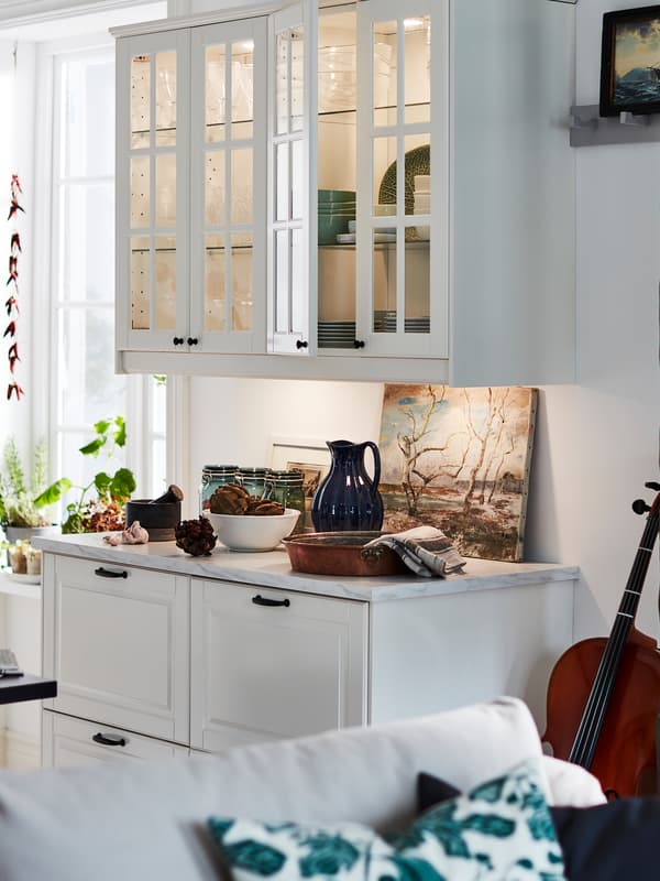 Armoires de cuisine avec portes blanc cassé, plan de travail quartz à effet marbre blanc et grands tiroirs blanc cassé.