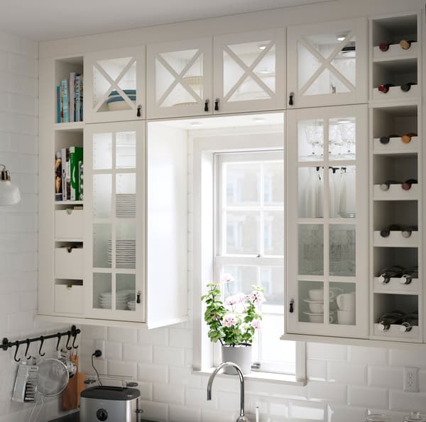 Armoires de cuisine IKEA TORNVIKEN blanches avec portes vitrées avec un croisillon en bois.