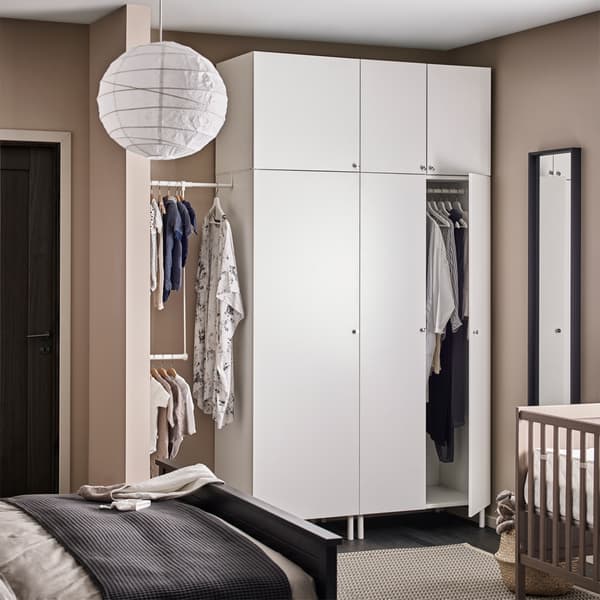 Armoires de rangement blanches dans une chambre à coucher beige.