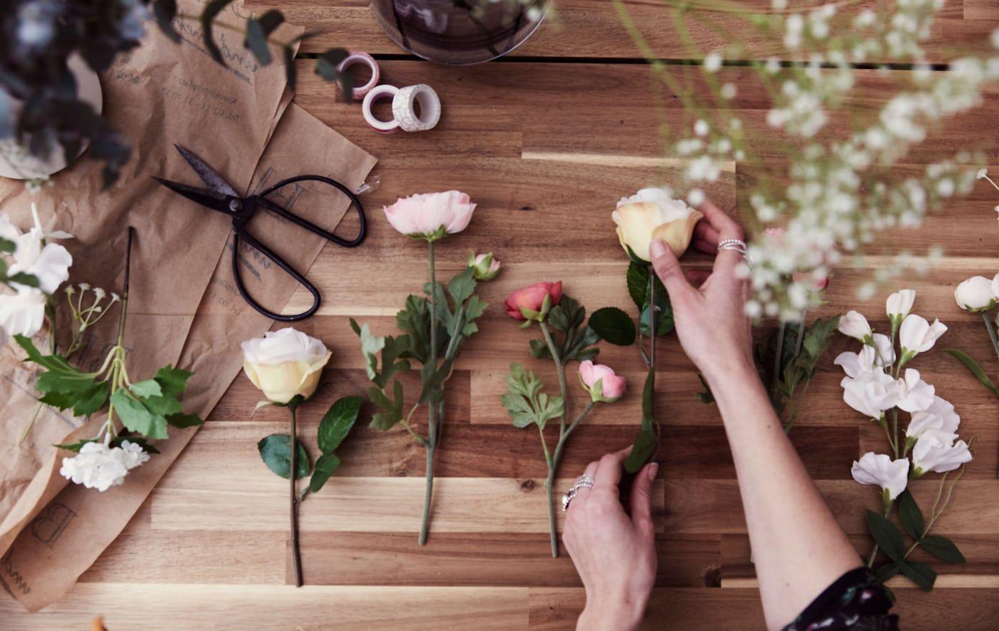 Artifical wedding flowers being prepared on a wooden table