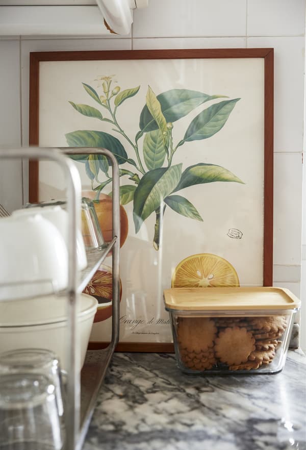 Artwork and food containers on a kitchen worktop.