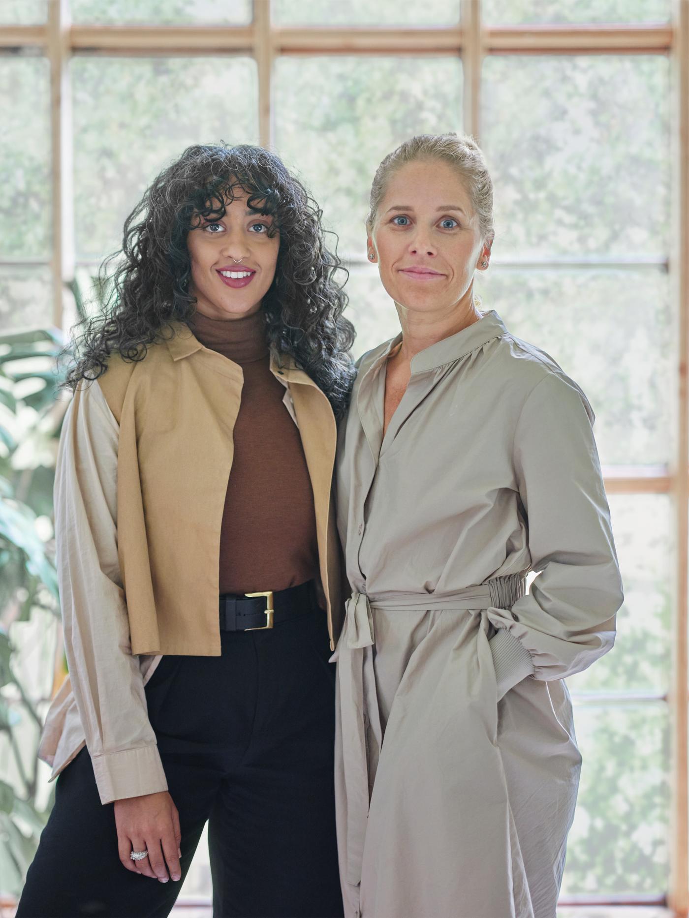 As deseñadoras de IKEA Akanksha Deo e Sarah Fager de pé diante dunha fiestra nun luminoso espazo con plantas.