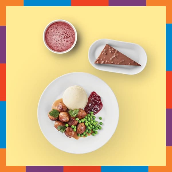 Assiette blanche ronde contenant des boulettes, une boule de purée et des petits pois à côté d'un ramequin blanc contenant une boisson rose et d'une part de gâteau au daim dans une petite assiette ovale détourés sur fond jaune pâle avec bordure de couleurs rouge, bleu, violet, orange et vert.