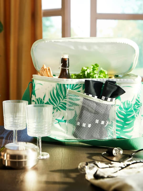 Asztal, rajta két KALLSINNIG pohár, mögöttük pedig egy SOMMARFLOX hűtőtáska.