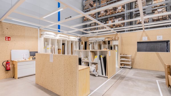 Atelier de tri intérieur avec rangements en bois recyclé et matériaux réutilisables, dans un environnement propre et structuré.