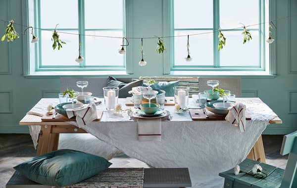 Attachez des fleurs artificielles à une ficelle que vous tendez au-dessus de la table, par exemple la fleur artificielle IKEA SMYCKA en blanc