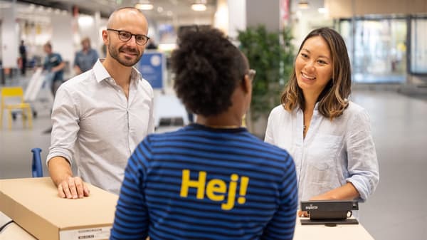 Au guichet du service clientèle IKEA, une collaboratrice conseille une cliente et un client qui souhaitent rendre un produit.