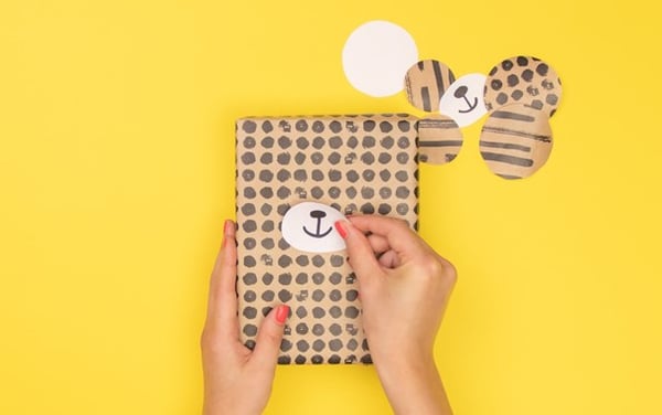 Auf einem Geschenk wird ein Tiermund angebracht.