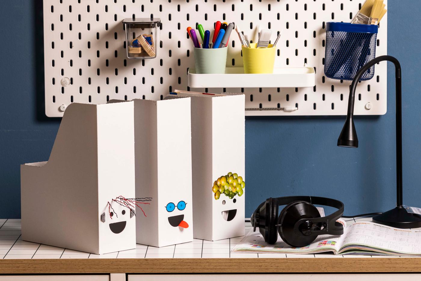 Auf einem Tisch stehen 3 Ordner und eine schwarze Tischlampe auf der rechten Seite auf einem braunen Tisch.