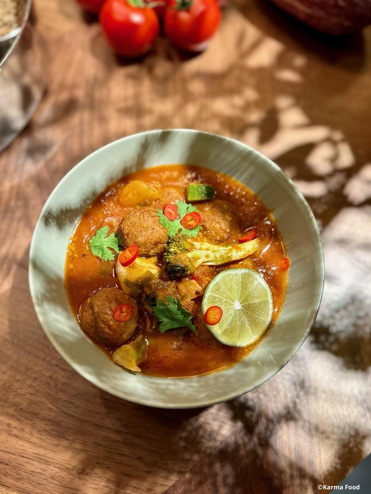 Auf einem Tisch steht ein grüner Teller mit leckerm Essen darauf. Auf der Seite kann man Deko sehen.